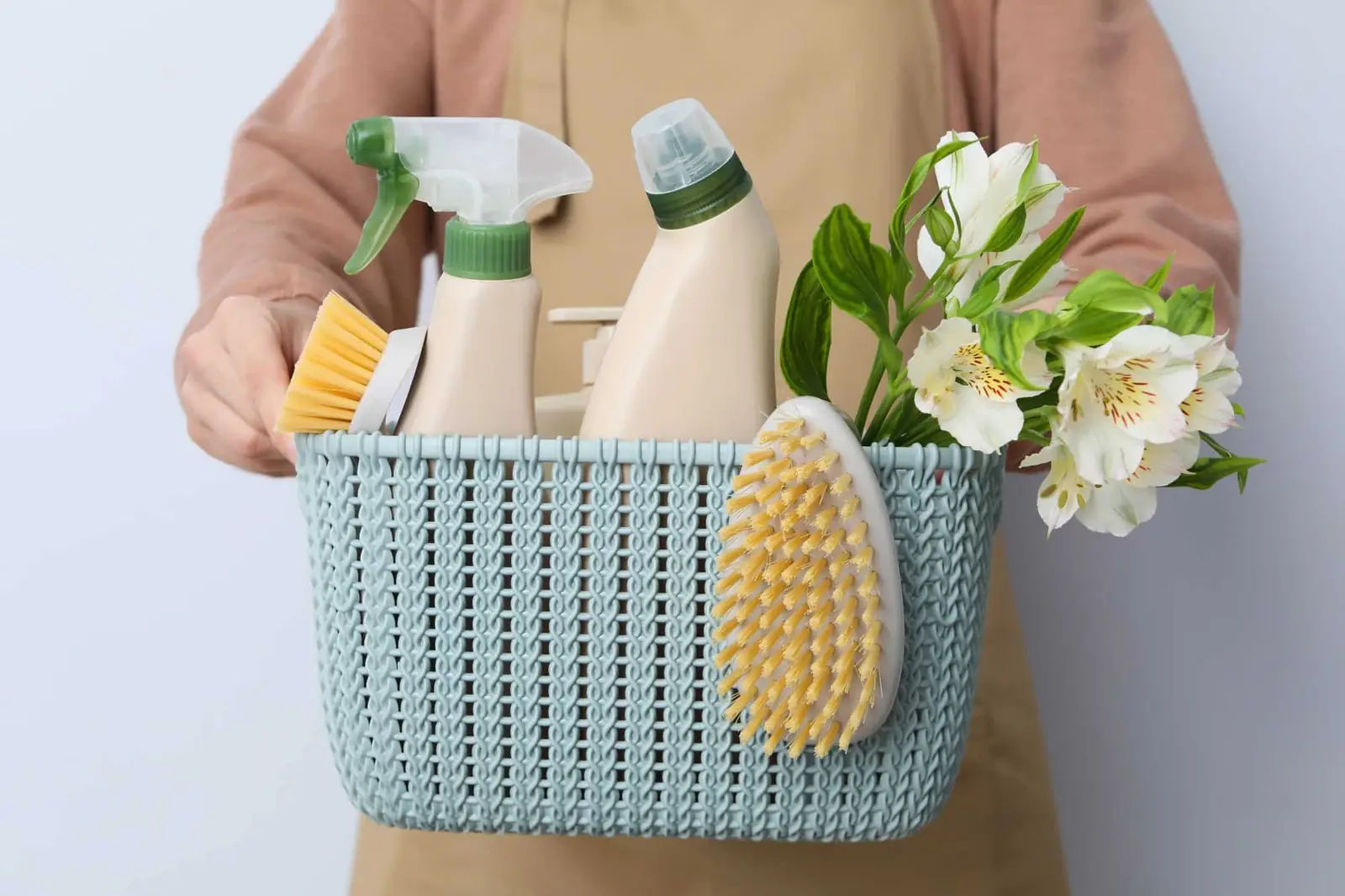 Un panier de produits et d'accessoires d'entretien ménager.